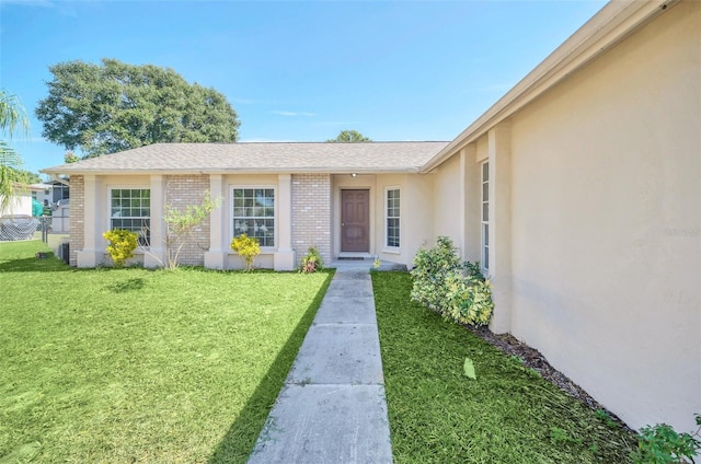 entrance to property featuring a lawn