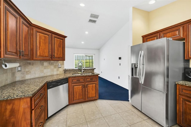 2204 Clementine Trl, Clermont, FL 34714 - kitchen with stainless steel appliances, a sink, light carpet, light tile patterned floors, and dark stone countertops