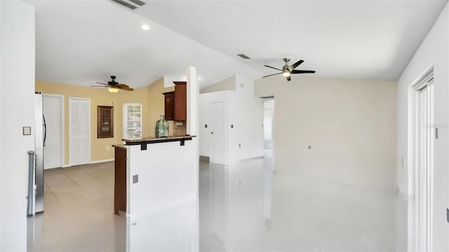 2204 Clementine Trl, Clermont, FL 34714 - kitchen featuring ceiling fan, vaulted ceiling, a breakfast bar area, a peninsula, and baseboards