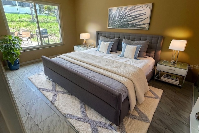 2204 Clementine Trl, Clermont, FL 34714 - bedroom featuring multiple windows, marble look tiles, and baseboards