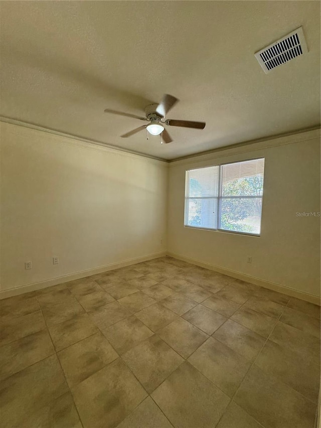 tiled spare room featuring ornamental molding, a textured ceiling, and ceiling fan