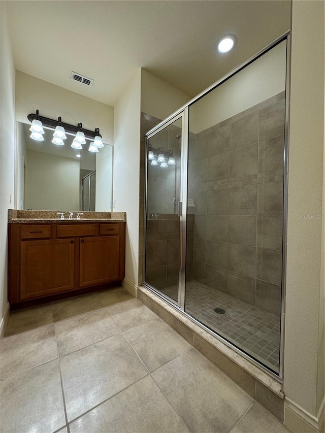 bathroom with vanity, walk in shower, and tile patterned flooring