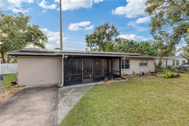 back of property with a yard and a sunroom