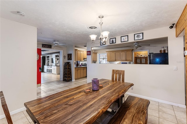 dining area with a textured ceiling, ceiling fan with notable chandelier, and light tile patterned floors