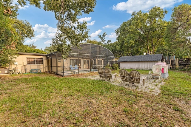 view of yard with a fenced in pool and glass enclosure