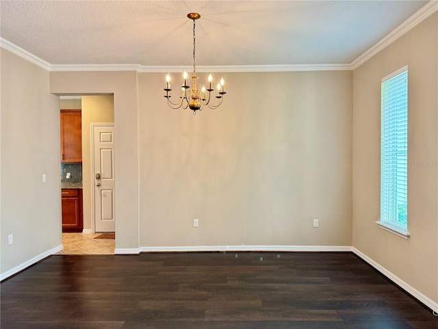 empty room with a textured ceiling, a notable chandelier, wood-type flooring, and ornamental molding