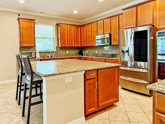 kitchen featuring a center island, ornamental molding, and appliances with stainless steel finishes