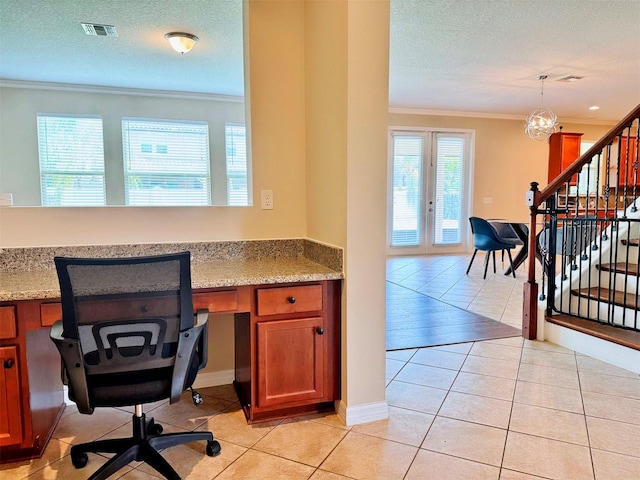 tiled office featuring french doors, built in desk, a textured ceiling, and crown molding