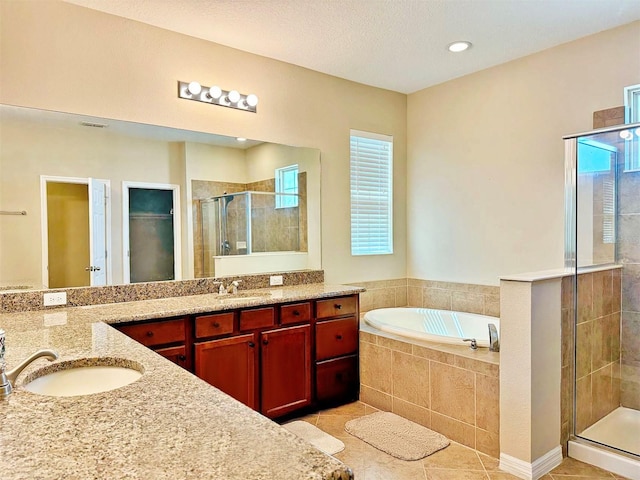 bathroom featuring tile patterned flooring, a textured ceiling, vanity, and separate shower and tub