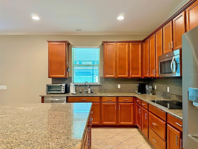 kitchen featuring light stone countertops, sink, stainless steel appliances, and ornamental molding