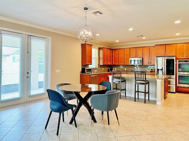 dining room with sink, light tile patterned floors, a healthy amount of sunlight, and ornamental molding