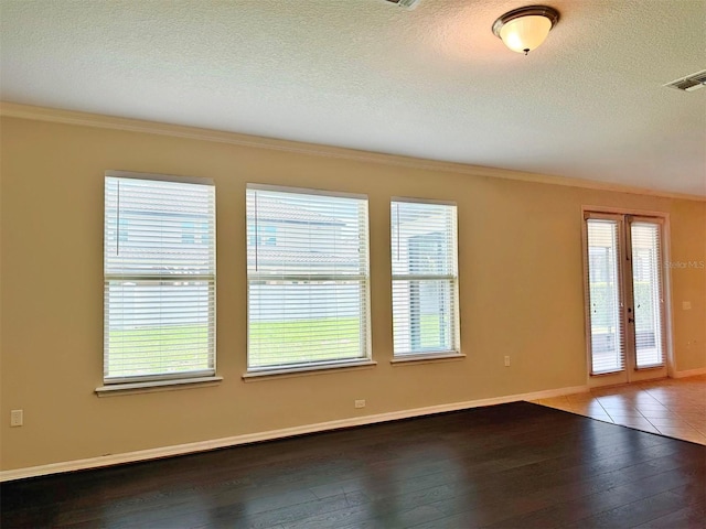 spare room featuring hardwood / wood-style flooring, ornamental molding, a textured ceiling, and french doors