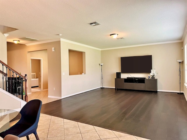 living room with a textured ceiling, light wood-type flooring, and ornamental molding