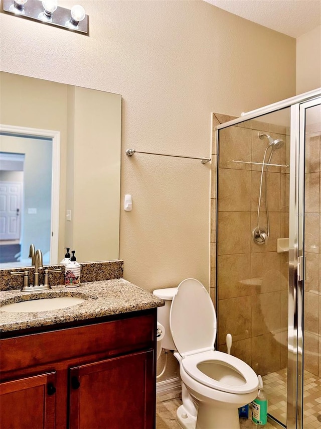 bathroom with vanity, an enclosed shower, and toilet