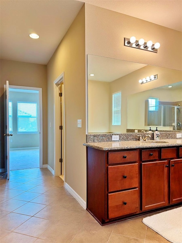 bathroom featuring tile patterned floors, vanity, and a shower with shower door