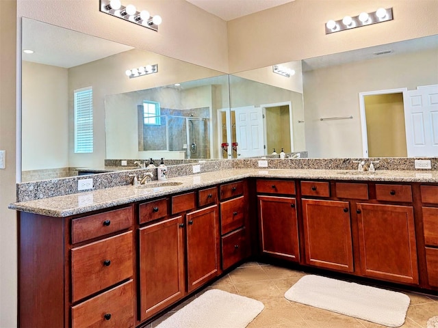 bathroom with tile patterned flooring, vanity, and a shower with door