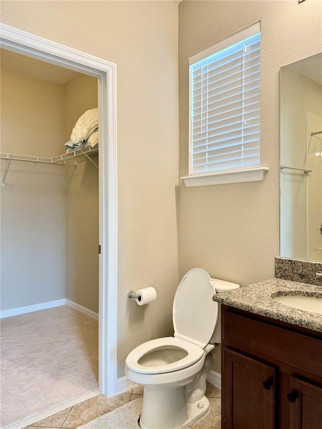 bathroom featuring tile patterned flooring, vanity, and toilet