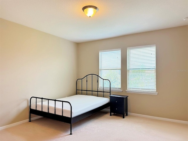 carpeted bedroom featuring a textured ceiling