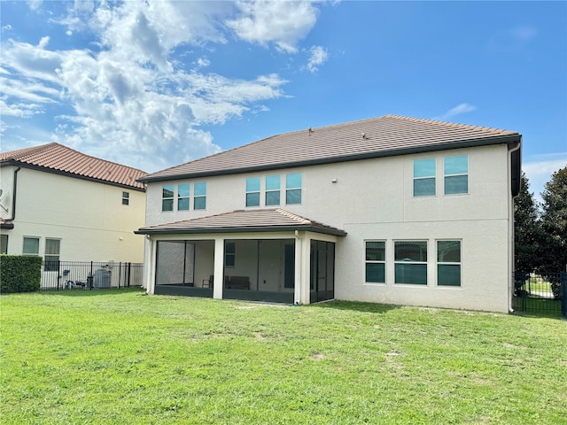 back of property with a lawn and a sunroom