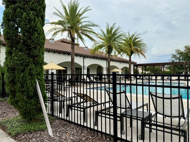 view of gate with a patio and a community pool