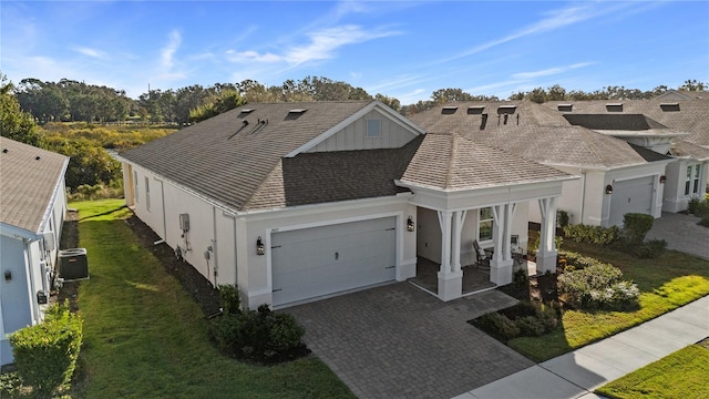 view of front facade featuring a porch, a front yard, a garage, and stucco siding