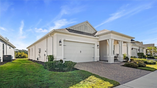 view of front of house featuring a front lawn, stucco siding, decorative driveway, board and batten siding, and an attached garage