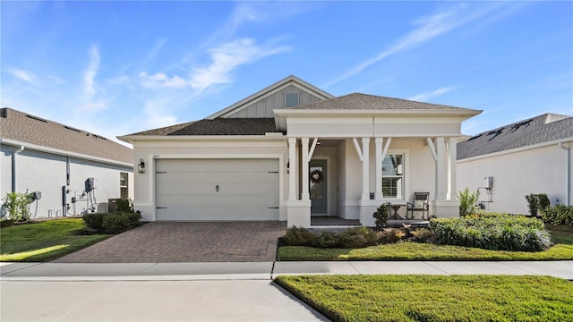 view of front facade featuring a porch, a front yard, stucco siding, driveway, and an attached garage