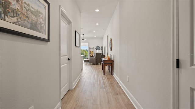 corridor with light wood-style floors, recessed lighting, and baseboards