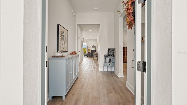 hallway with baseboards, recessed lighting, visible vents, and light wood-style flooring