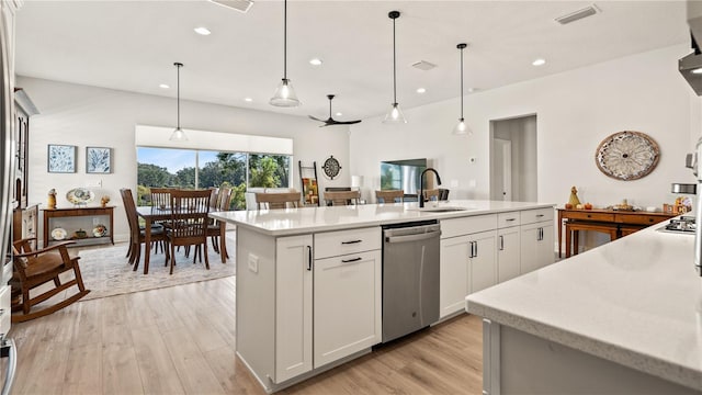 kitchen featuring white cabinetry, stainless steel dishwasher, pendant lighting, and a kitchen island with sink