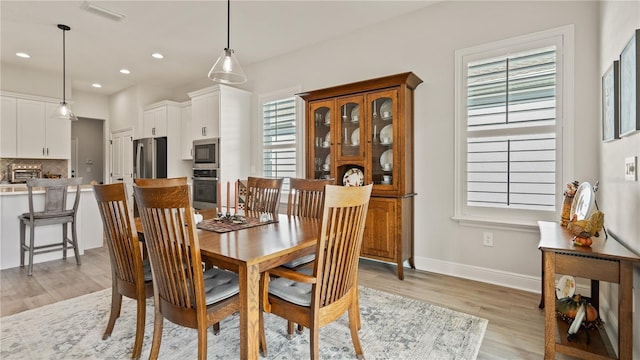 dining area with plenty of natural light, recessed lighting, visible vents, and light wood-type flooring