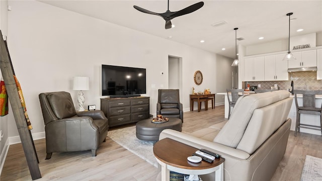 living room with recessed lighting, a ceiling fan, light wood-style flooring, and baseboards