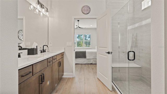 full bath with wood finished floors, a shower stall, double vanity, ensuite bathroom, and a sink