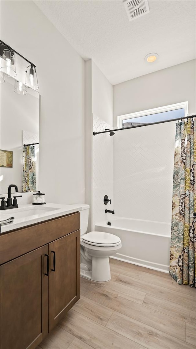 full bathroom featuring vanity, shower / bath combo with shower curtain, wood-type flooring, and toilet