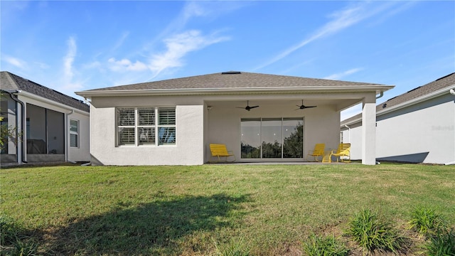 back of property featuring a ceiling fan, a yard, and stucco siding