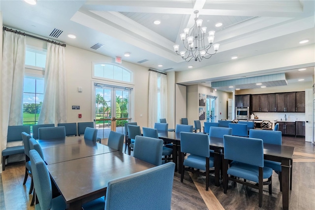 dining area with a notable chandelier, dark wood-type flooring, coffered ceiling, visible vents, and french doors