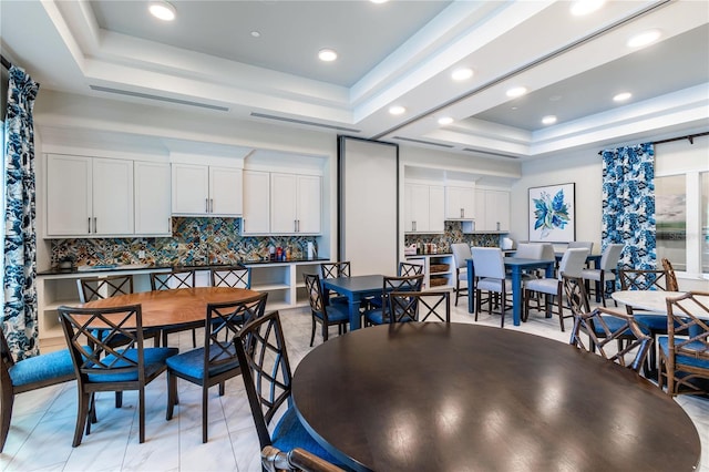 dining space featuring recessed lighting and a raised ceiling