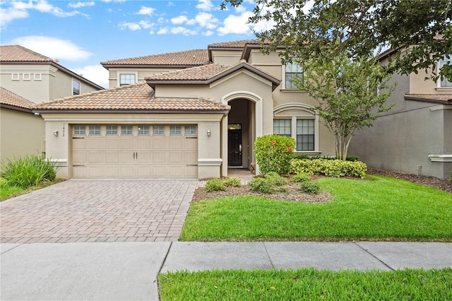 1473 Moon Valley Dr, Davenport, FL 33896 - mediterranean / spanish house with decorative driveway, stucco siding, a garage, and a front yard