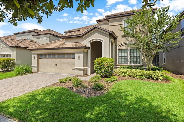 mediterranean / spanish-style house featuring a front lawn and a garage