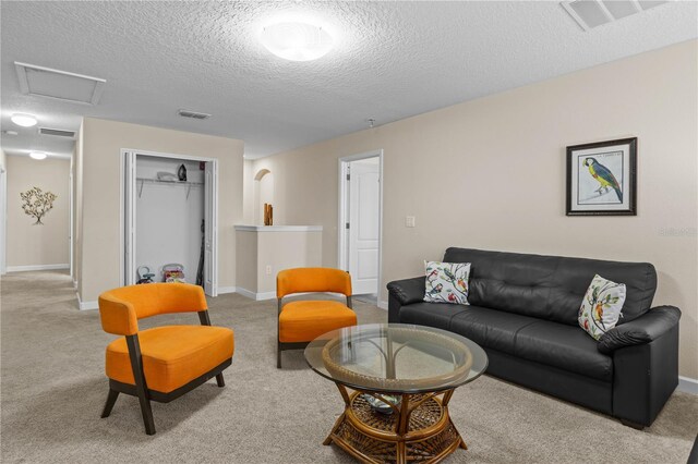 living room featuring light carpet and a textured ceiling