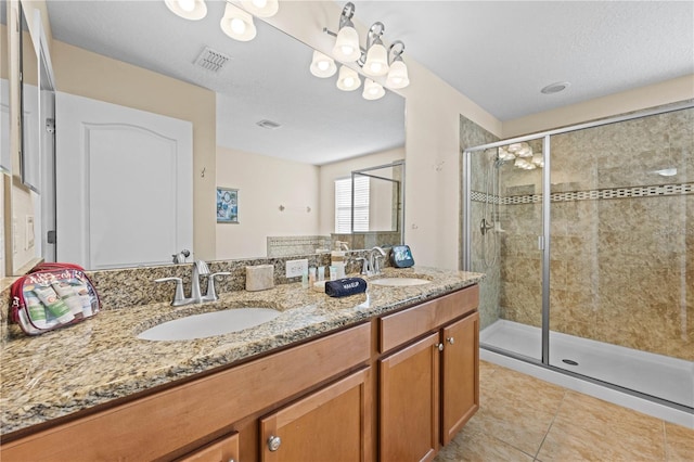 bathroom with tile patterned flooring, vanity, and a shower with door