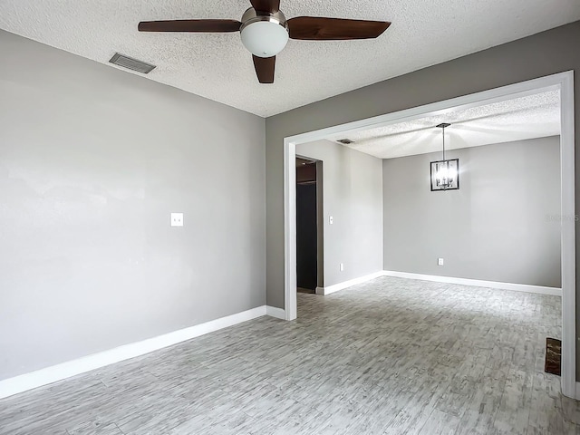 empty room with hardwood / wood-style flooring, ceiling fan, and a textured ceiling