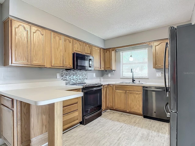 kitchen featuring sink, tasteful backsplash, black appliances, a textured ceiling, and kitchen peninsula