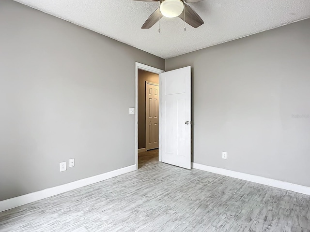 empty room featuring a textured ceiling, ceiling fan, and light hardwood / wood-style flooring