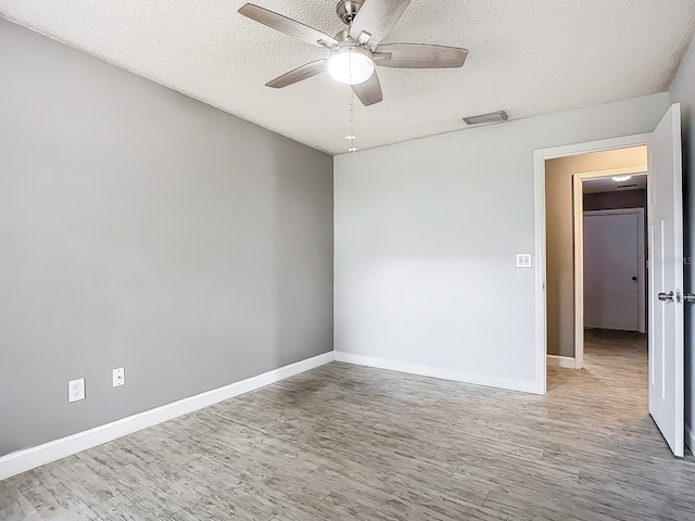 empty room featuring hardwood / wood-style floors, a textured ceiling, and ceiling fan