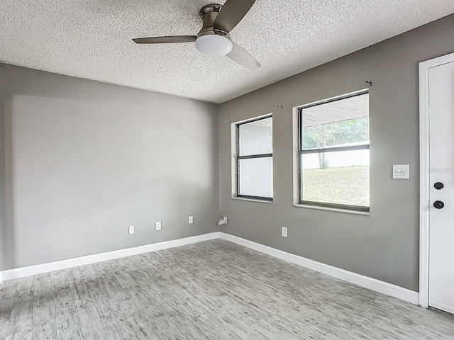 spare room with a textured ceiling, light hardwood / wood-style flooring, and ceiling fan