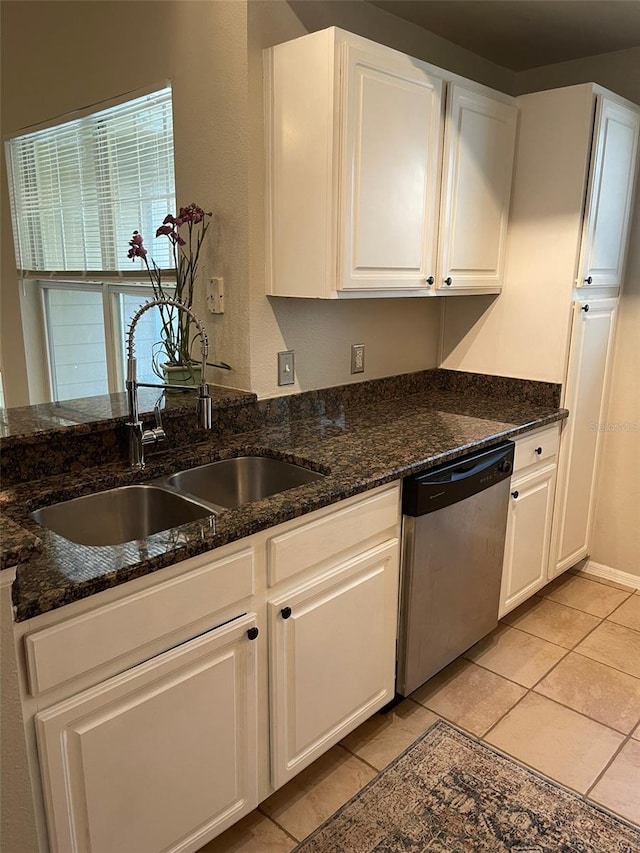 kitchen featuring dark stone counters, stainless steel dishwasher, sink, and white cabinets