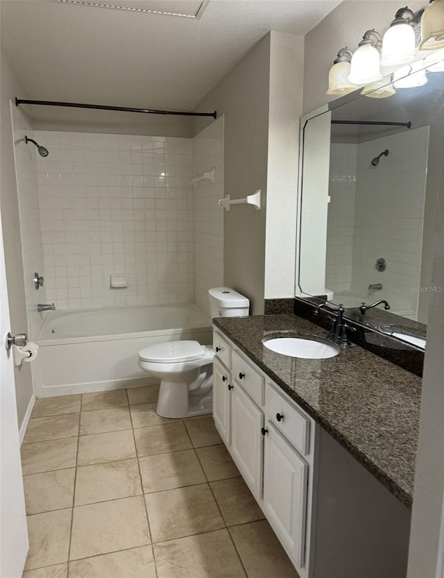 full bathroom featuring tile patterned flooring, vanity, toilet, and tiled shower / bath combo