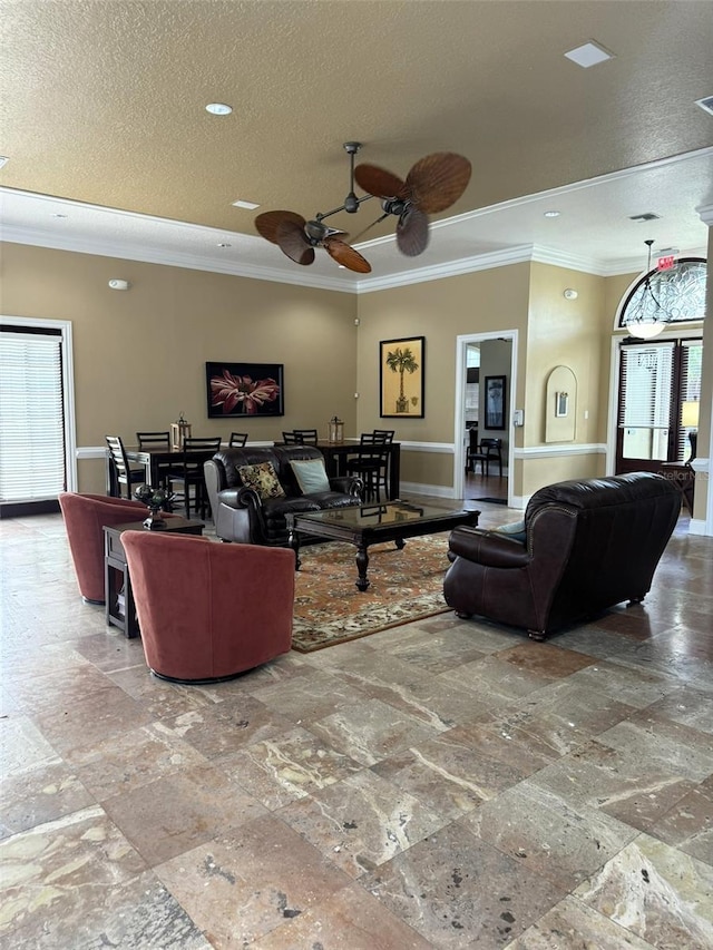 living room featuring ornamental molding, a textured ceiling, and ceiling fan