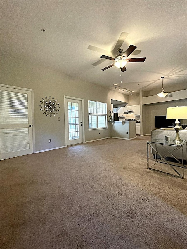 unfurnished living room featuring ceiling fan, a textured ceiling, and carpet